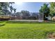 Large, level backyard offers ample space for recreation with a screened pool at 3629 Lake Breeze Dr, Land O Lakes, FL 34639