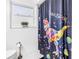 Bright bathroom features a whimsical dinosaur-themed shower curtain and white fixtures at 3629 Lake Breeze Dr, Land O Lakes, FL 34639