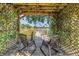 Beautiful lake view from the dock with rocking chairs under a trellis covered in flowering vines at 3629 Lake Breeze Dr, Land O Lakes, FL 34639