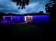 Charming home exterior illuminated with purple lights, showcasing unique stone accents at 3629 Lake Breeze Dr, Land O Lakes, FL 34639