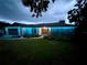 Charming home exterior illuminated with blue lights, showcasing unique stone accents at 3629 Lake Breeze Dr, Land O Lakes, FL 34639