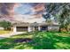 Charming home featuring a lush green lawn, mature tree, and a two-car garage at 3629 Lake Breeze Dr, Land O Lakes, FL 34639