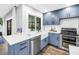 Contemporary kitchen with a farmhouse sink, stainless steel appliances, blue cabinets, and marble countertops at 3629 Lake Breeze Dr, Land O Lakes, FL 34639