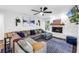 Comfortable living room with sectional sofa, ceiling fan, modern accents, and a stone fireplace at 3629 Lake Breeze Dr, Land O Lakes, FL 34639