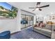 Open living space with a large sectional, ceiling fan, and glass doors leading to a patio and backyard at 3629 Lake Breeze Dr, Land O Lakes, FL 34639