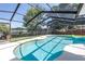Sparkling pool with a safety fence in a screened-in enclosure overlooking the lake at 3629 Lake Breeze Dr, Land O Lakes, FL 34639