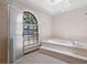 Relaxing bathroom showcases a soaking tub, a glass-enclosed shower, and a large window for a spa-like experience at 3808 Hollow Wood Dr, Valrico, FL 33594