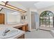 Bright bathroom featuring a large vanity, walk-in shower, and arched window at 3808 Hollow Wood Dr, Valrico, FL 33594