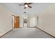 An open concept bedroom with large neutral carpet, ceiling fan, and multiple windows create a peaceful retreat at 3808 Hollow Wood Dr, Valrico, FL 33594