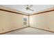 Bedroom features a neutral color scheme, ceiling fan, and a window overlooking greenery at 3808 Hollow Wood Dr, Valrico, FL 33594