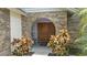Inviting double front doors framed by brick archway and colorful plants at 3808 Hollow Wood Dr, Valrico, FL 33594