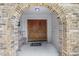 Inviting double front doors framed by brick archway, bench, and overhead light at 3808 Hollow Wood Dr, Valrico, FL 33594