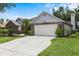 Attached two-car garage with a brick accented exterior that is surrounded by a landscaped yard at 3808 Hollow Wood Dr, Valrico, FL 33594
