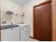 Functional laundry room featuring washer, dryer, shelving and a door at 3808 Hollow Wood Dr, Valrico, FL 33594