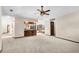 Open living room with neutral walls and ceiling fan, and a view of the kitchen with bar seating at 3808 Hollow Wood Dr, Valrico, FL 33594