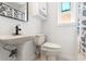 Bathroom featuring a pedestal sink, white toilet, and window at 408 Pineapple St, Tarpon Springs, FL 34689