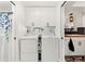 Laundry room featuring a washer, dryer, and overhead cabinets at 408 Pineapple St, Tarpon Springs, FL 34689