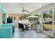 Screened-in patio with outdoor dining furniture, ceiling fan, and access to backyard at 408 Pineapple St, Tarpon Springs, FL 34689