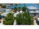 An aerial view shows a waterfront property with lush trees, a grey roof, and views of the nearby marina at 412 20Th Ave, Indian Rocks Beach, FL 33785