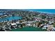 An aerial view of waterfront houses with pools and boat docks are along a wide canal at 412 20Th Ave, Indian Rocks Beach, FL 33785