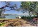 Backyard with mature trees is shown in this sunny picture looking out to the canal with private dock at 412 20Th Ave, Indian Rocks Beach, FL 33785