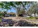A backyard view shows the yard and the house, with a glimpse of the backyard pool beyond at 412 20Th Ave, Indian Rocks Beach, FL 33785
