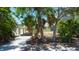 Cozy home exterior with carport surrounded by trees and some greenery at 412 20Th Ave, Indian Rocks Beach, FL 33785
