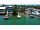 This aerial view showcases a waterfront lot with docks and boat lifts on a sunny day in Florida at 412 20Th Ave, Indian Rocks Beach, FL 33785