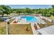 Aerial view of community pool with ample seating, lounge chairs, and umbrellas in a landscaped setting at 4326 Venice Dr, Land O Lakes, FL 34639