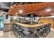 Well-stocked bar featuring a light countertop, wood trim, unique ceiling tiles and multiple barstools at 4326 Venice Dr, Land O Lakes, FL 34639