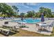 Community swimming pool surrounded by seating, umbrellas, and well-maintained landscaping at 4326 Venice Dr, Land O Lakes, FL 34639