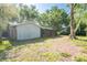 A large fenced backyard with a partially covered patio and mature trees at 4442 Summer Oak Dr, Tampa, FL 33618