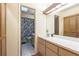 Bathroom with a long vanity, mirror, and view into a shower/toilet room with floral shower curtain at 4442 Summer Oak Dr, Tampa, FL 33618