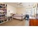 Bedroom featuring a ceiling fan, shelf full of books and a desk area next to the window at 4442 Summer Oak Dr, Tampa, FL 33618