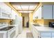 Galley kitchen features white appliances, white cabinetry, breakfast bar, and yellow accent wall at 4442 Summer Oak Dr, Tampa, FL 33618