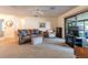 Cozy living room with neutral carpet, brown sofa, ceiling fan and glass sliding doors leading to a screened area at 4442 Summer Oak Dr, Tampa, FL 33618