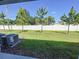 Backyard featuring a green lawn, young trees, and white vinyl fence providing privacy for outdoor enjoyment at 4461 Globe Thistle Dr, Tampa, FL 33619