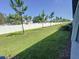 Large backyard featuring a white fence, well-maintained lawn, and young trees, offering privacy and space at 4461 Globe Thistle Dr, Tampa, FL 33619