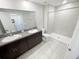 Bathroom features dual sinks with granite countertops, dark wood cabinets, a large mirror and tiled walk-in shower at 4461 Globe Thistle Dr, Tampa, FL 33619