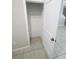 A view of a closet with white walls, tile flooring, and a shelf at 4461 Globe Thistle Dr, Tampa, FL 33619