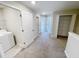 Hallway with carpet floors, white doors, and a view into other rooms, including a laundry room at 4461 Globe Thistle Dr, Tampa, FL 33619