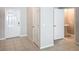 Well-lit hallway with tile flooring, white walls, and doorways to a bathroom at 4461 Globe Thistle Dr, Tampa, FL 33619