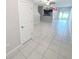 Bright, open-concept living area with neutral tile flooring and sliding glass doors at 4461 Globe Thistle Dr, Tampa, FL 33619
