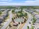 A picturesque aerial view of a community with water features, lush landscaping, and charming homes under a bright sky at 4644 Almada Ln, Wesley Chapel, FL 33543