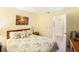 Cozy bedroom featuring floral bedding, soft lighting, and a doorway to a private bath at 5216 81St N St # 2, St Petersburg, FL 33709