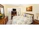 Relaxing bedroom with floral bedding, wooden furniture, and a view of the bathroom at 5216 81St N St # 2, St Petersburg, FL 33709