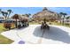 Relaxing community space featuring two tiki umbrellas, benches, picnic tables, grills, and landscaping at 5216 81St N St # 2, St Petersburg, FL 33709