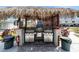Outdoor grilling area offering stainless steel grills under a tiki hut roof in a well-maintained community space at 5216 81St N St # 2, St Petersburg, FL 33709