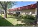 Manicured lawn and landscaping surrounding the condo with a red tile roof at 601 N Hercules Ave # 1602, Clearwater, FL 33765