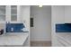 Stylish kitchen with white marble countertops, blue subway tile backsplash, and white cabinetry at 601 N Hercules Ave # 1602, Clearwater, FL 33765